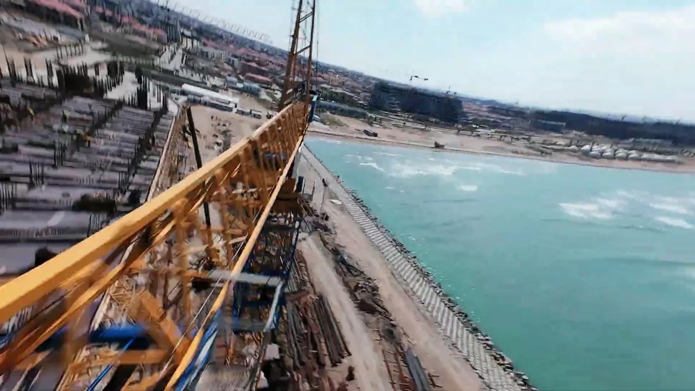 A crane jib above the building and the sea