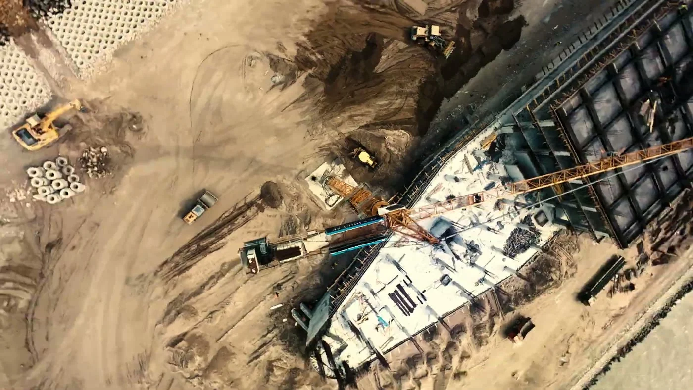 Aerial view: machinery, sand and the side of the hull