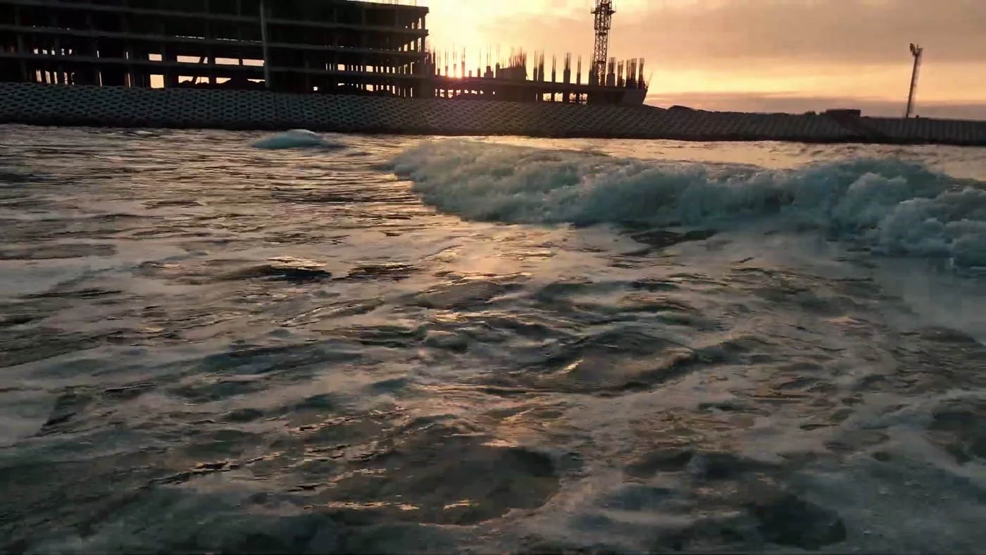 Waves at the rock revetment, the building in the distance